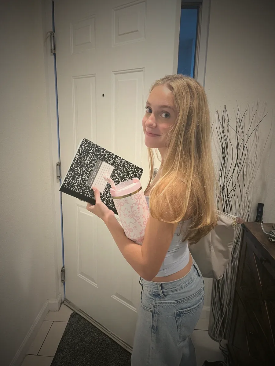 Chiara smiling at the front door on her first day of college