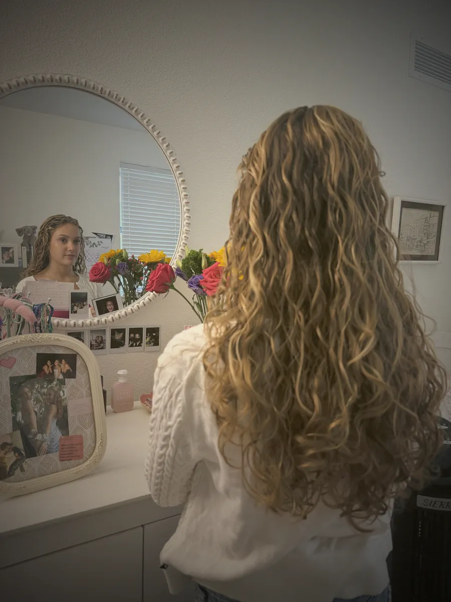Chiara looking at herself in her bedroom mirror